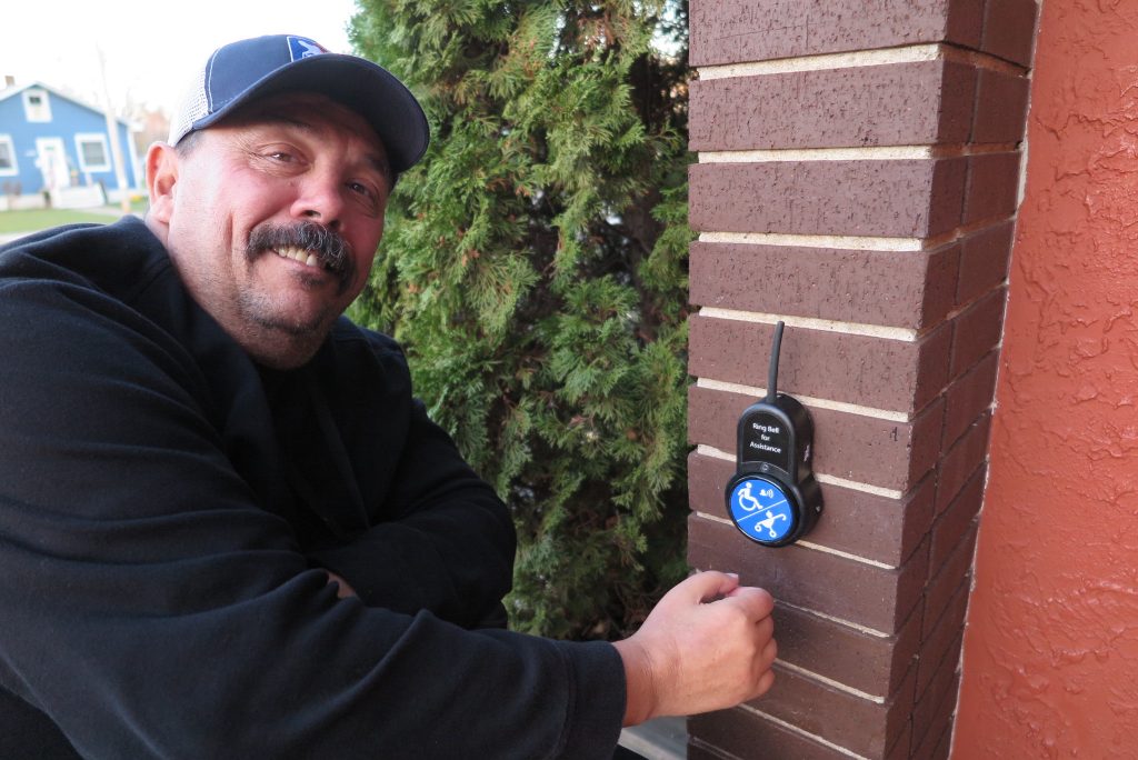 Appleton Wisconsin Alderman Joe Martin utilizes the BigBell to notify the staff inside Mark's East Side restaurant that he needs some assistance with the front door. (photo credit: Inclusion Solutions)